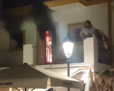 Dos hombres subiendo al primer piso del Bar Costa con un extintor.