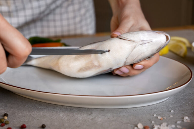 front view cook cleaning fish kitchen