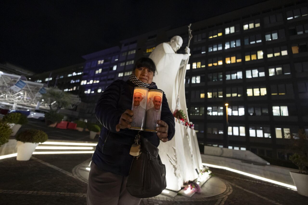 Una mujer enciende velas durante una oración de la comunidad boliviana en el Hospital Gemelli, donde está hospitalizado el Papa Francisco