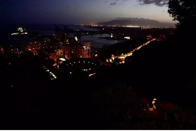 Vista general del encendido paulatino de la ciudad de Málaga durante el apagón eléctrico generalizado.