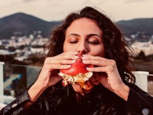 Mujer comiendo una hamburguesa en la azotea de Unexpected Ibiza Hotel