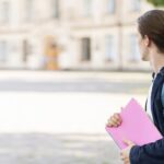 elegante estudiante en el campus mirando otro lado