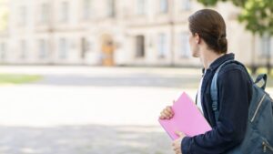 elegante estudiante en el campus mirando otro lado
