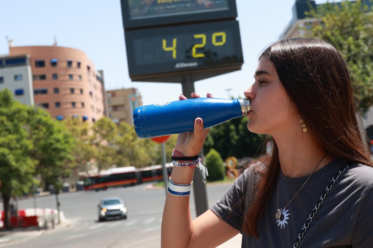 Una chica bebiendo agua un día de calor extremo.