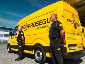 Dos vigilantes de Prosegur ante un vehículo ligero eléctrico.