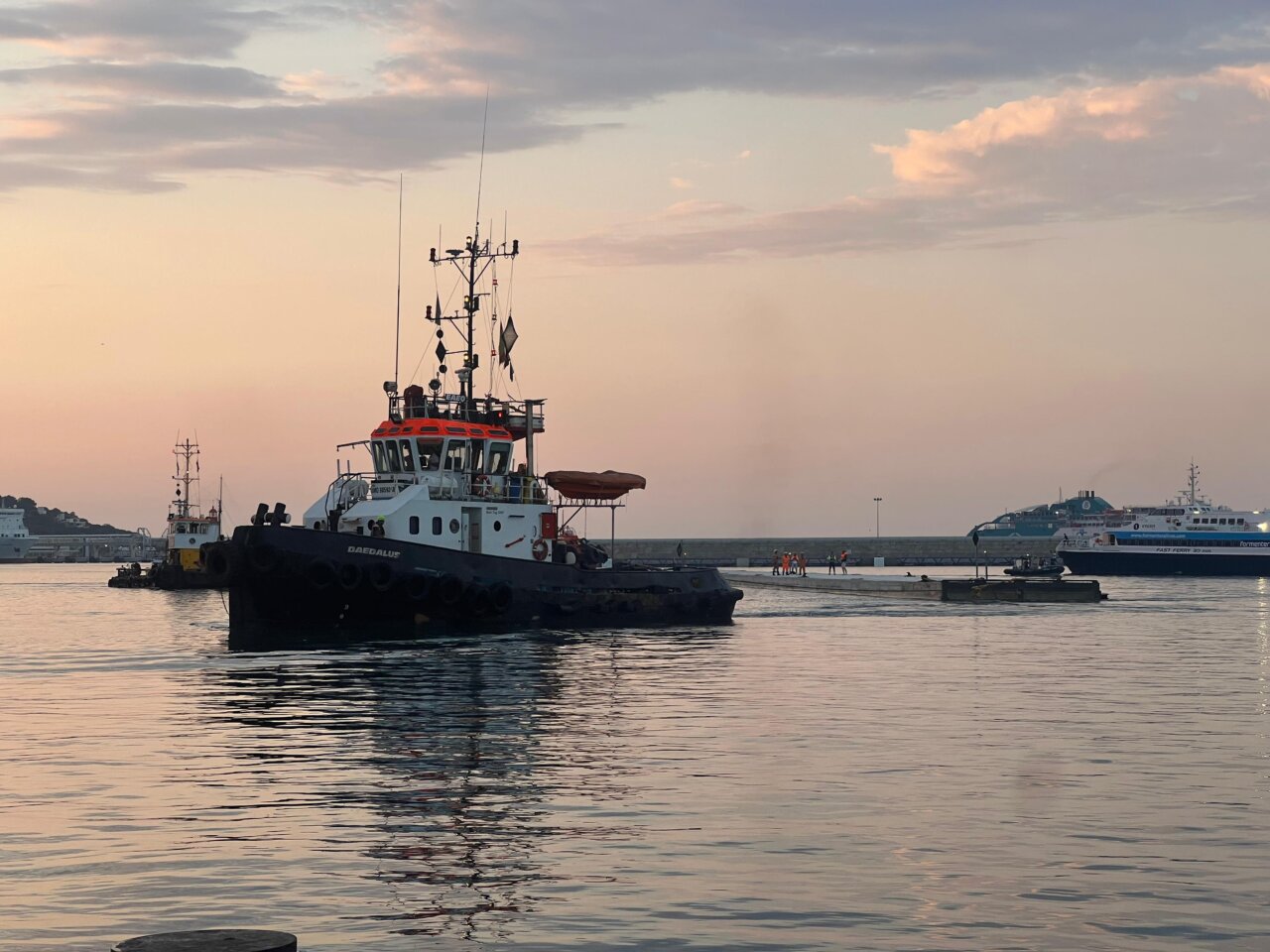 El dique flotante acercándose a la zona en la que será instalado con la ayuda de un remolcador. El dique flotante acercándose a la zona en la que será instalado con la ayuda de un remolcador.