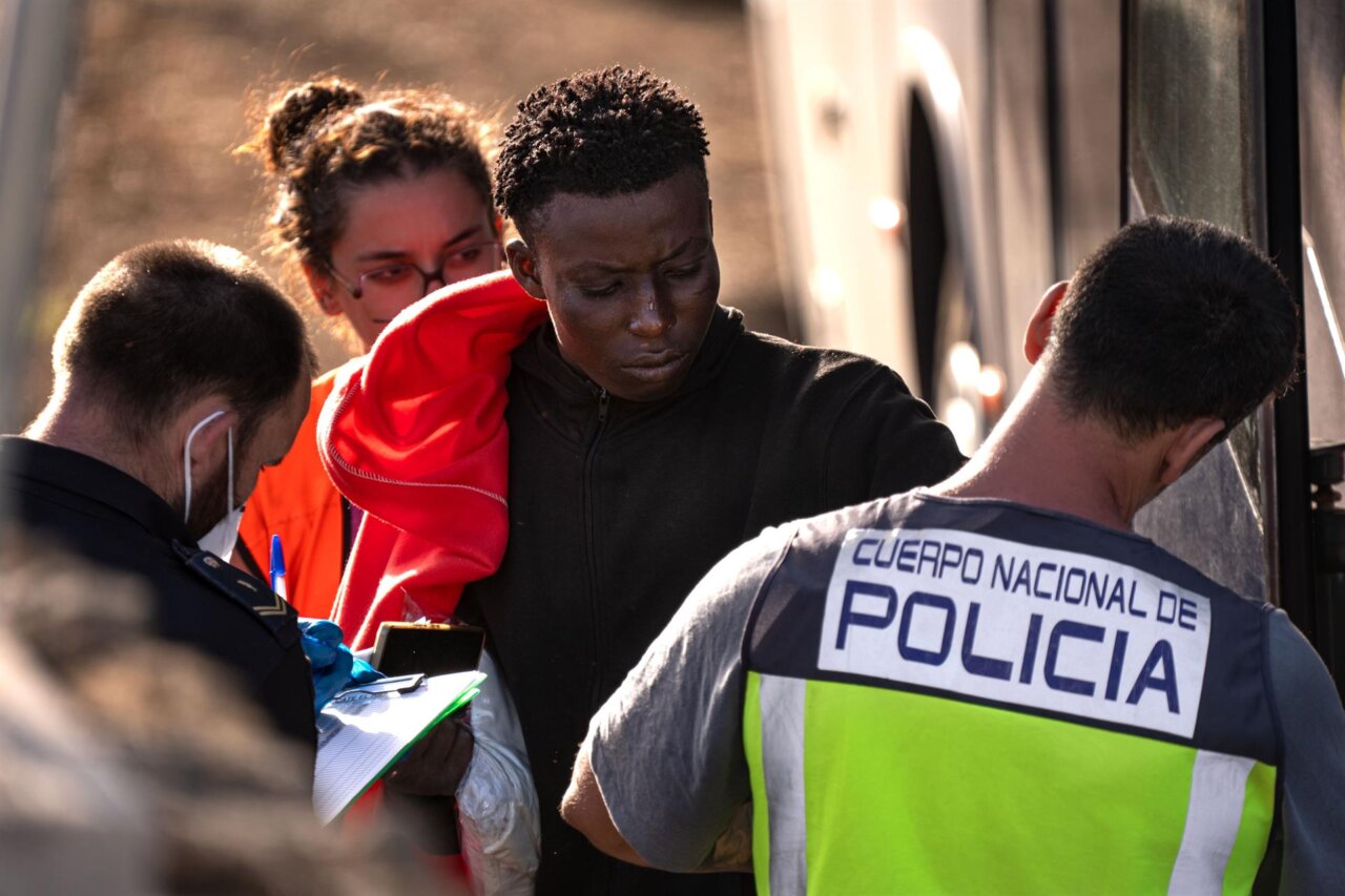 Un migrante es atendido por un policía.