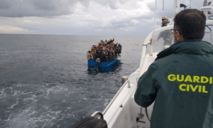 un guardia civil observa una patera con inmigrantes 8 865x518 (1)