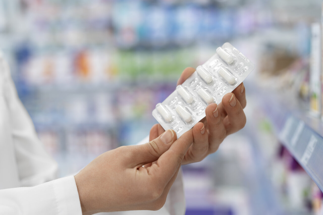 Persona sostiene una tableta de medicamentos.