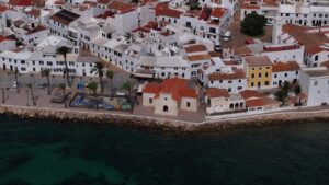 Vista a&eacute;rea del puerto de Fornells con casas blancas y mar