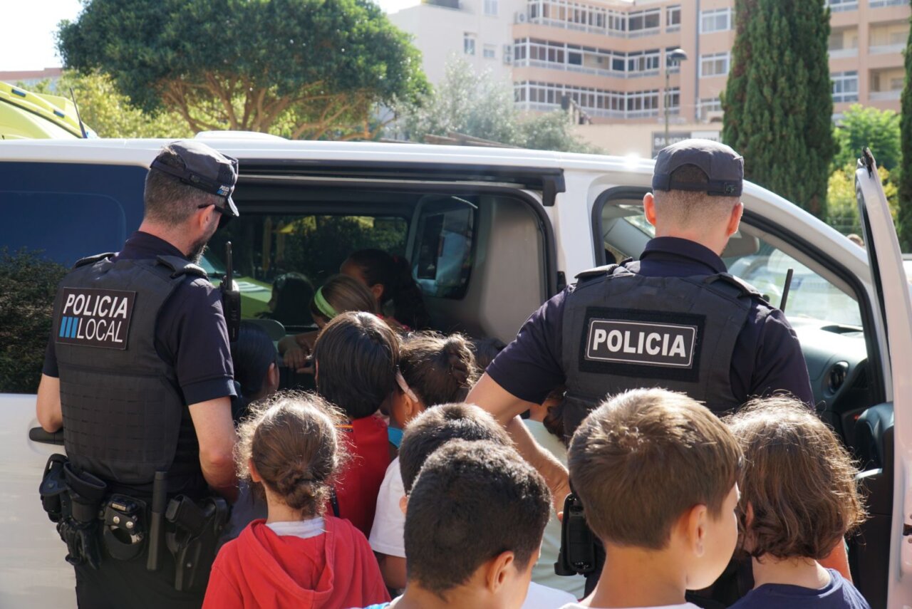 Niños observando a la policía local en una jornada de educación vial