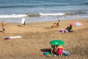 Varias personas en la playa durante la suspensión de clases por la ola de calor, a 11 de octubre de 2023, en Las Palmas de Gran Canaria, Gran Canaria, Islas Canarias (España).