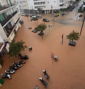 Vista aérea de una calle inundada con vehículos y árboles