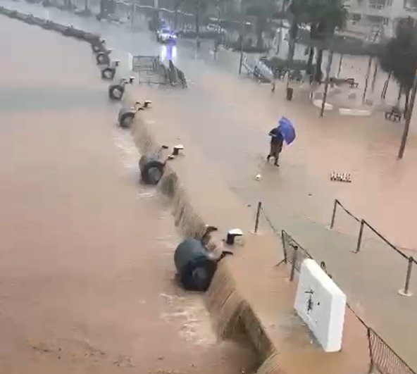 Inundación en el puerto de Ibiza con un hombre bajo la lluvia