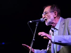 Pablo Guerrero cantando en un escenario durante un concierto