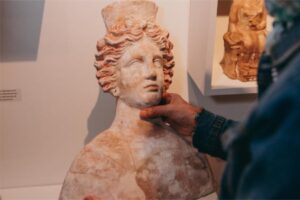 Persona tocando una escultura en el Museo Arqueol&oacute;gico de Eivissa