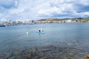 Hombre en paddleboard en la costa de Ibiza durante un evento solidario