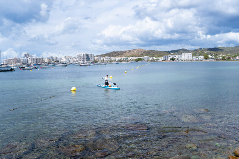 Hombre en paddleboard en la costa de Ibiza durante un evento solidario