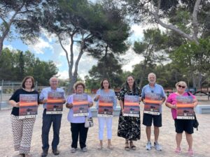 Grupo de personas sosteniendo carteles de las Festes de Cala de Bou 2025