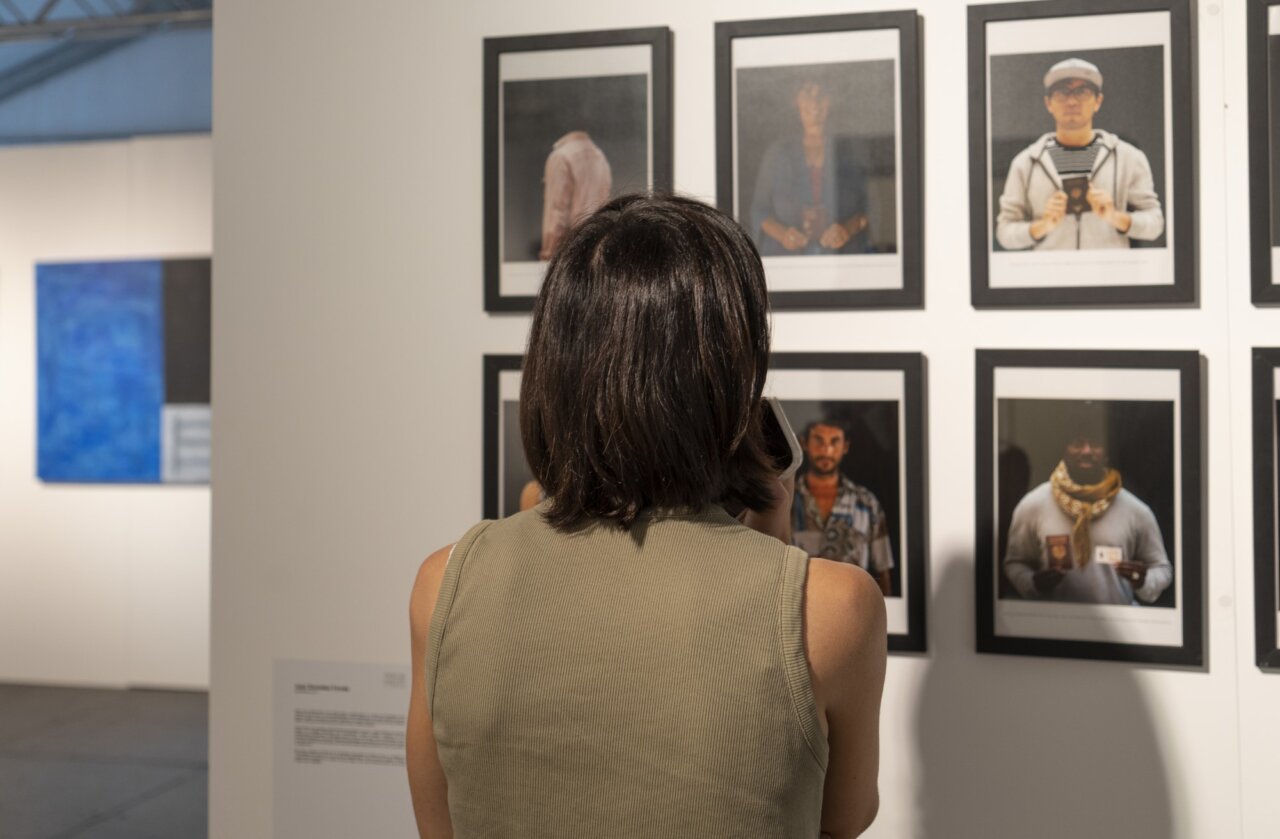Persona observando fotografías en una exposición de arte en Formentera