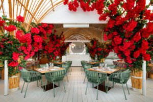 Interior del restaurante The Beach decorado con flores rojas