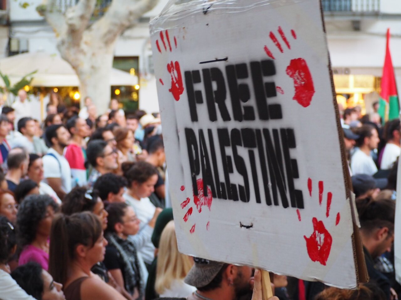 Protesta con cartel que dice Free Palestine en una multitud.