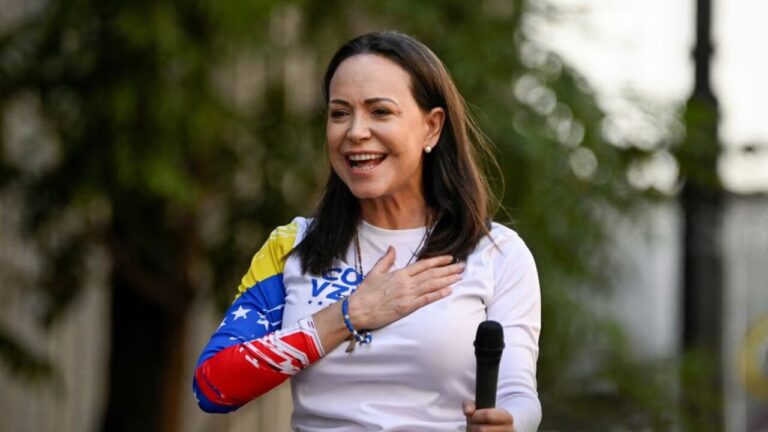 María Corina Machado sonriendo mientras sostiene un micrófono