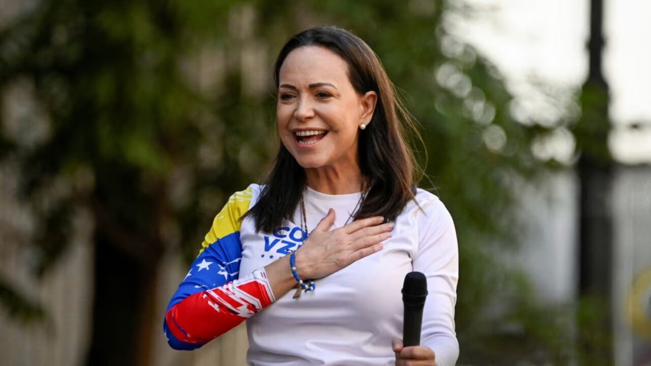 María Corina Machado sonriendo mientras sostiene un micrófono
