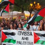 Manifestación con banderas palestinas y pancartas en apoyo a Palestina.