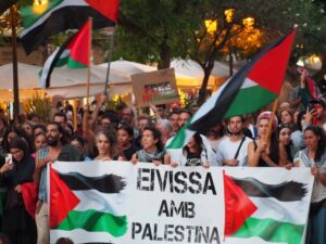 Manifestación con banderas palestinas y pancartas en apoyo a Palestina.