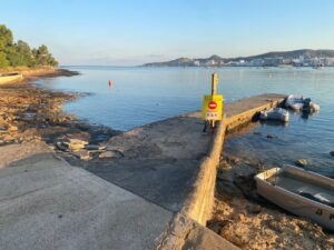 Vista de la playa de Punta Xinx&oacute; con se&ntilde;al de prohibici&oacute;n de ba&ntilde;o.