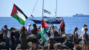 Manifestantes sosteniendo banderas palestinas en la flotilla Global Sumud.