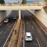 Vista de una carretera bajo un puente con varios vehículos