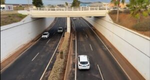 Vista de una carretera bajo un puente con varios vehículos