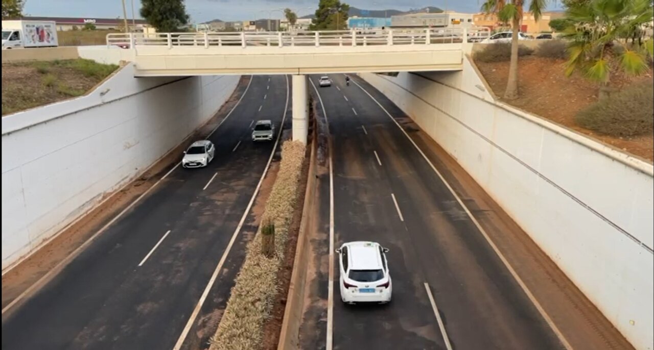 Vista de una carretera bajo un puente con varios vehículos