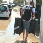 Persona cargando maletas en una calle inundada en Ibiza