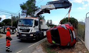 Una grúa remueve un coche volcado tras un accidente en Ibiza.