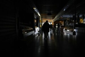 Personas en un establecimiento oscuro durante un apagón eléctrico masivo.