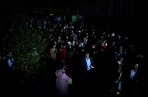 Multitud de personas en un ambiente oscuro durante un apagón eléctrico.