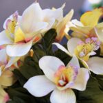 Ramo de flores artificiales en tonos amarillos y blancos.