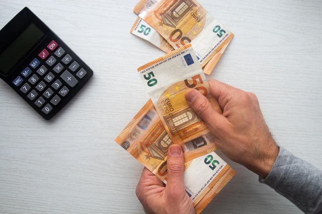 Persona contando billetes de 50 euros sobre una mesa