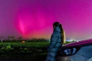 Auroras boreales en el cielo con una persona observando.