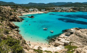 Vista panorámica de Cala Tarida en Ibiza con aguas turquesas y barcos