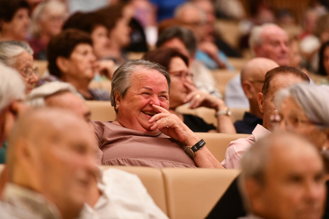 Mujer mayor riendo en un evento comunitario en Santa Eulària des Riu.