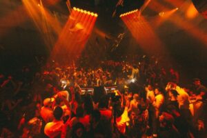 Multitud celebrando en la reapertura de Chinois Ibiza con luces y música