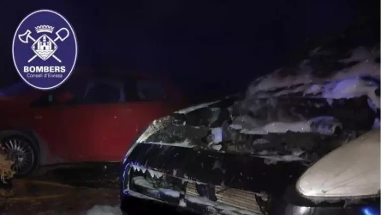 Coche negro dañado por un incendio en la noche