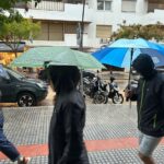 Personas caminando bajo la lluvia con paraguas en Ibiza