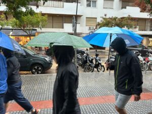 Personas caminando bajo la lluvia con paraguas en Ibiza