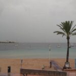 Vista de la playa en Ibiza durante la DANA con barcos y palmeras