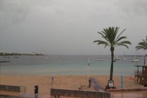 Vista de la playa en Ibiza durante la DANA con barcos y palmeras